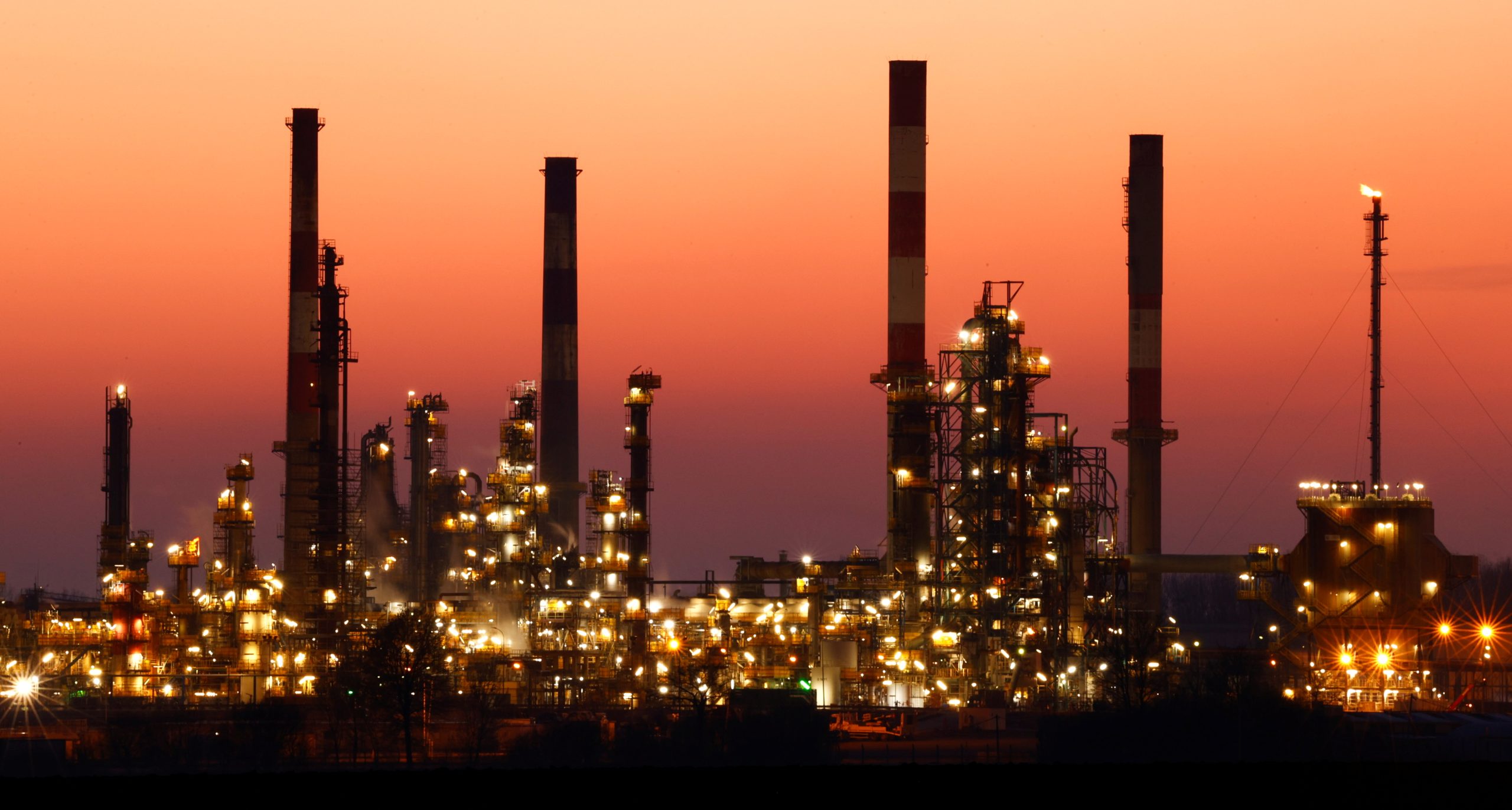 FILE PHOTO: The chimneys of the Total Grandpuits oil refinery are seen just after sunset, southeast of Paris, France, March 1, 2021.  REUTERS/Christian Hartmann